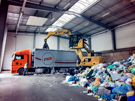 a large truck with a load of trash in a warehouse